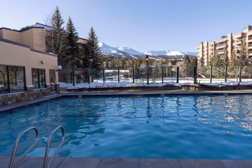 a swimming pool with snow covered mountains in the background at NEW! Marriott Slope View Ski in Ski out Luxury Studio Sleeps 4 Full kitchen, Amenities & Fee Parking in Breckenridge