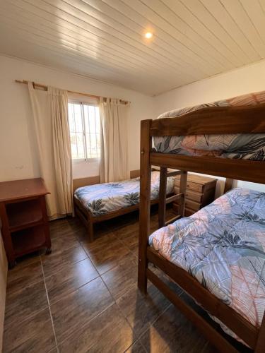 a bedroom with two bunk beds and a window at Finca Los Arrieros - Malargüe in Malargüe