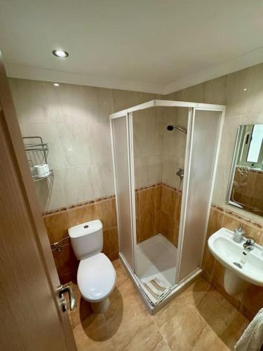 a bathroom with a shower and a toilet and a sink at Peaceful 2 bed, 2 bath flat & breathtaking views in Mellieħa