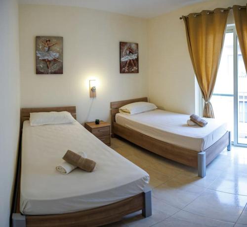 a bedroom with two beds and a window at Peaceful 2 bed, 2 bath flat & breathtaking views in Mellieħa