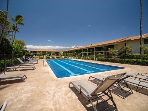 a swimming pool with lounge chairs next to a building at WBH D227 Aloha Lai - Breathtaking Ocean Views in Kihei