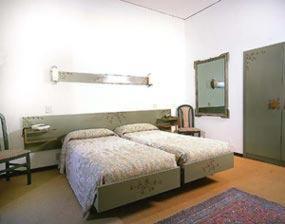 a bedroom with a bed and a mirror on the wall at Hotel Kennedy in SantʼAlessio Siculo