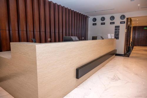 a reception desk in an office with a wooden wall at Jadeel Hotel in Al Khobar