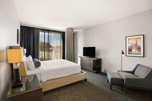 a hotel room with a bed and a chair at Sonesta Bee Cave Austin Hill Country in Bee Cave
