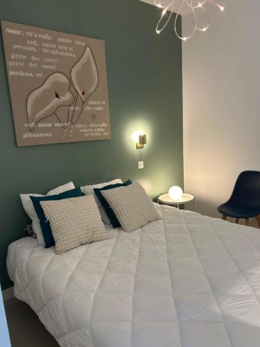 une chambre avec un grand lit blanc avec des oreillers dans l'établissement Location appartements 2 pièces, aux Pennes-Mirabeau