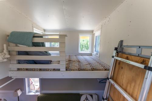 a small room with two bunk beds in a tiny house at Little Red Caboose in Oakhurst
