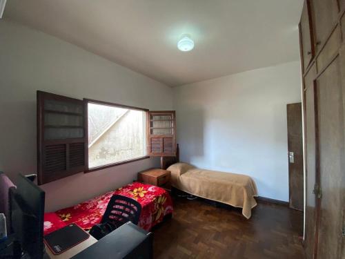 a small room with a bed and a window at República Os Bartira in Ouro Preto