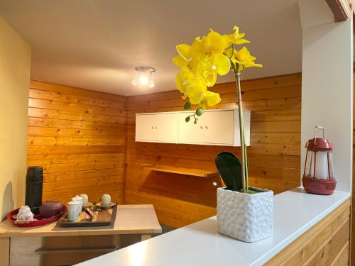 a vase with yellow flowers on a counter in a room at Whispering Pines Farmhouse in Redmond