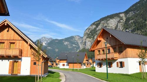 a village with wooden buildings and mountains in the background at Holiday Homes Obertraun - Oberösterreich 86 in Obertraun