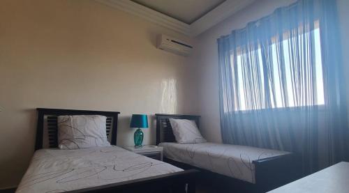 a bedroom with two beds and a window at perla Saïdia in Saidia 