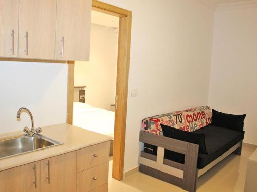a kitchen with a sink and a chair with a mirror at Le Caravelle Beirut in Beirut