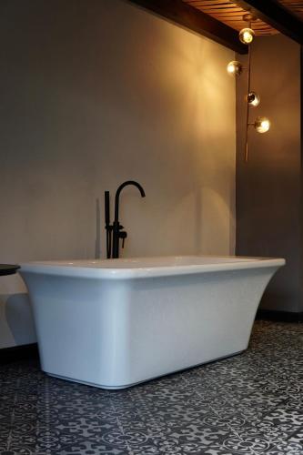 a bath tub with a faucet in a bathroom at Hotel Piedras Neg in San Miguel de Allende