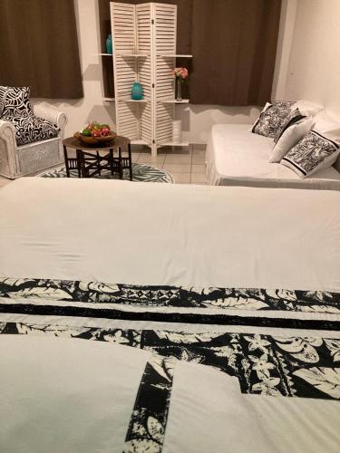a living room with two beds and a couch at L'Extension in Paea