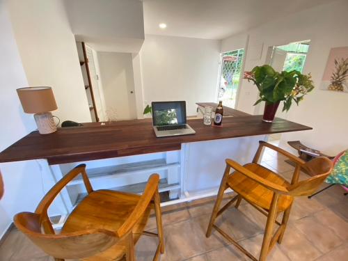 a desk with a laptop computer on it with two chairs at L'Extension in Paea