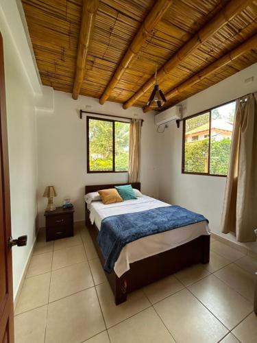 a bedroom with a bed with a wooden ceiling at Casa Otti-Olón in Olón