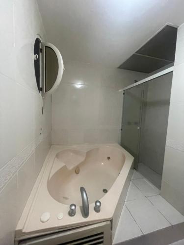 a white bathroom with a tub and a shower at Playa Almedro RESORT in Volcán Chimborazo