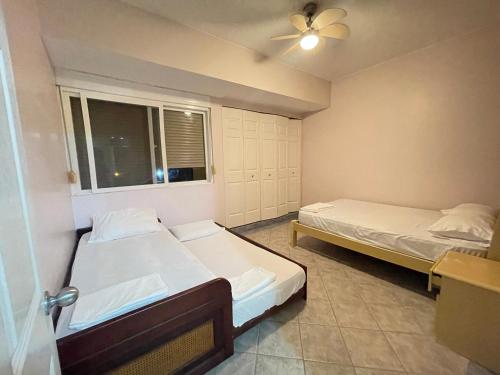 two beds in a small room with a window at Playa Almedro RESORT in Volcán Chimborazo