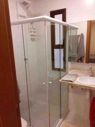 a bathroom with a glass shower and a sink at Vista espetacular em Itacimirim in Itacimirim
