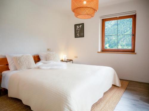 a bedroom with a large white bed and a window at Haus Arlberg in Pettneu am Arlberg