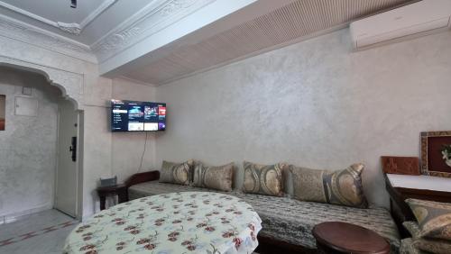 a living room with a couch and a tv on the wall at Airport apartment in Marrakech