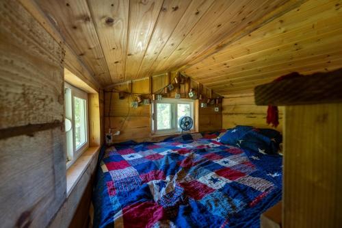 a bed in a log cabin with a quilt on it at Hawk's Rest in Oakhurst