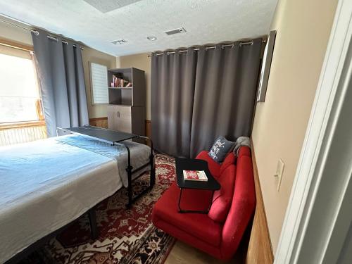a bedroom with a bed and a red chair at Irena Bed and Breakfast in Middleburg Heights