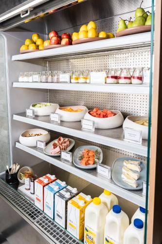 a refrigerator filled with lots of food and drinks at Vibe Hotel Melbourne in Melbourne