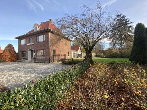 a brick house with a driveway in front of it at Secretarishuis in Grote-Brogel