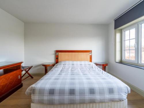 a bedroom with a large bed and a window at Secretarishuis in Grote-Brogel