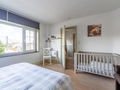 a bedroom with a crib and a window at Secretarishuis in Grote-Brogel