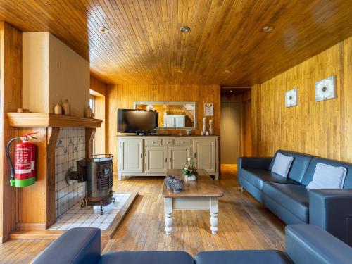 a living room with a blue couch and a fireplace at Het Bruegelhof in Grote-Brogel