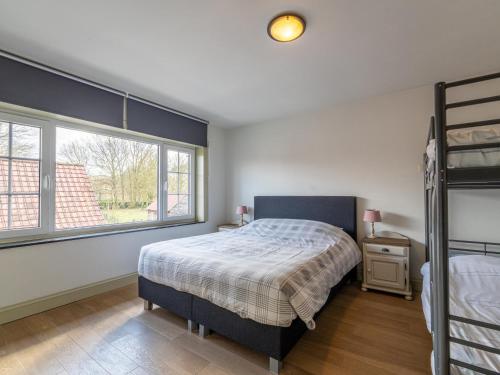 a bedroom with a bed and a large window at Het Bruegelhof in Grote-Brogel
