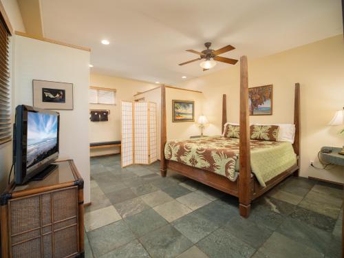 une chambre avec un lit et une télévision à écran plat dans l'établissement Aloha Aku CoCoPalm2 Suite - Your Cozy Beachfront Escape, à Kihei