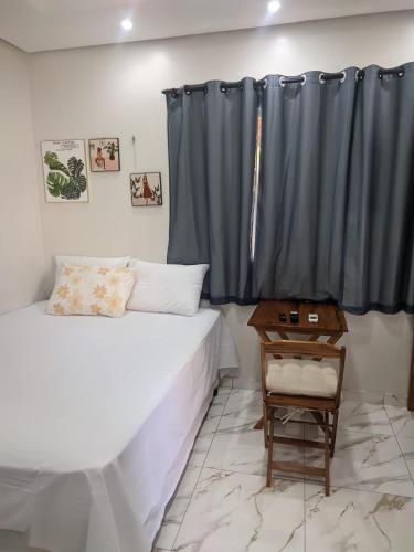 a bedroom with a bed and a black curtain at POUSADA NOSSO CANTO ALTER in Alter do Chao