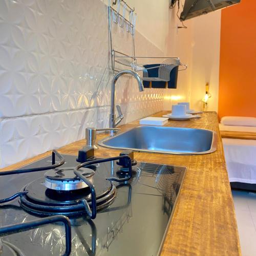 una cocina con estufa y fregadero en Morada da Lena - Praia do Forte, en Farol