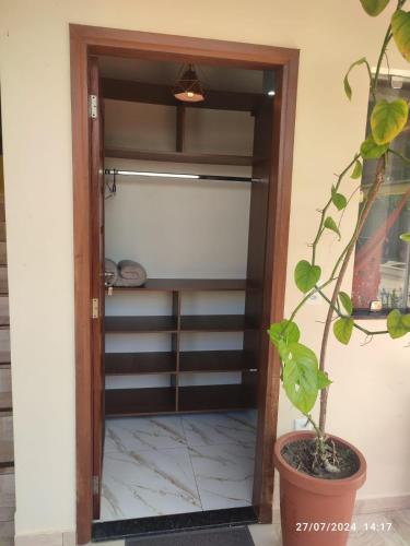 a door into a closet with a potted plant at POUSADA NOSSO CANTO ALTER in Alter do Chao
