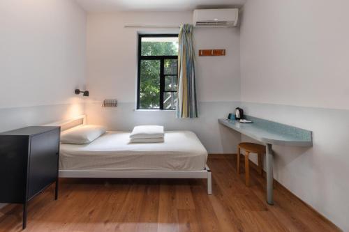 a bedroom with a bed and a desk and a window at Shenzhen Loft Youth Hostel in Shenzhen