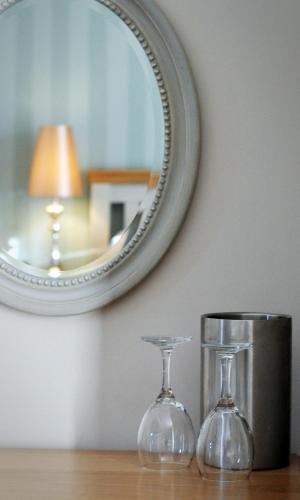 dos copas de vino en una mesa con un espejo en Newport Links Golf Club , Pembrokeshire en Newport