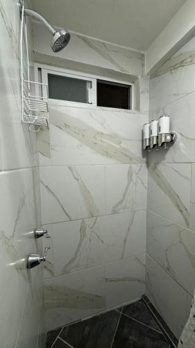 a bathroom with white marble walls and a window at Casa los Arcos Oaxaca in Oaxaca City