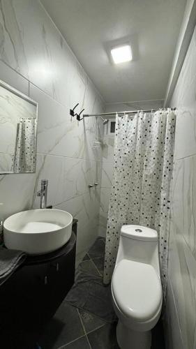a bathroom with a white toilet and a sink at Casa los Arcos Oaxaca in Oaxaca City