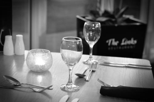 tres copas de vino sentadas sobre una mesa en Newport Links Golf Club , Pembrokeshire en Newport