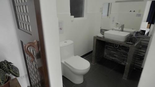 a bathroom with a white toilet and a sink at Fantasy Lodge in Samboan