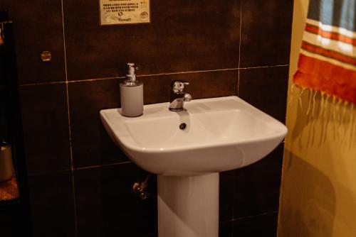 a white sink in a bathroom with black tiles at Fantasy Lodge in Samboan