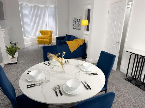 a dining room with a white table and blue chairs at Hampton Blues 3BR Entire Home in Stockton-on-Tees