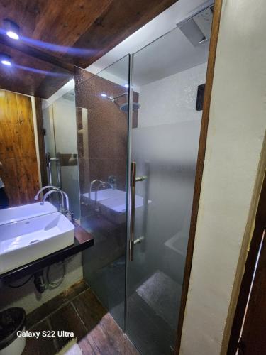 a bathroom with a glass shower and a sink at 1BR Northpoint Condo Free Airport pick up for 3 nights stay or more in Cabaguio