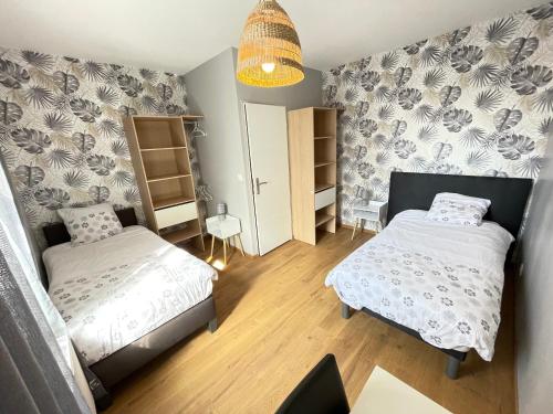 a small bedroom with two beds and a table at Gîte avec jardin au cœur des remparts de Gravelines in Gravelines