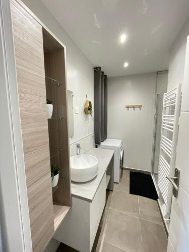 a white bathroom with a sink and a toilet at Gîte avec jardin au cœur des remparts de Gravelines in Gravelines