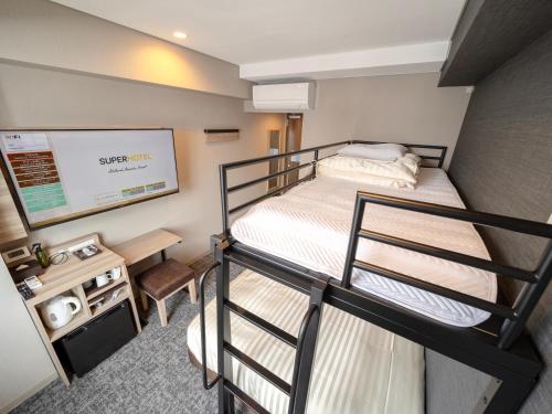 a small room with a bunk bed and a tv at Super Hotel Sendaieki Higashiguchi Tennenonsen in Sendai