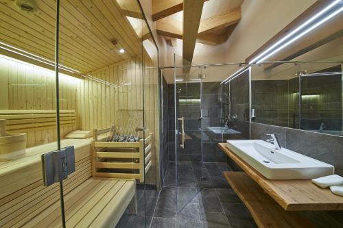 duża łazienka z umywalką i prysznicem w obiekcie Appartements Liebe Heimat w Saalbach Hinterglemm