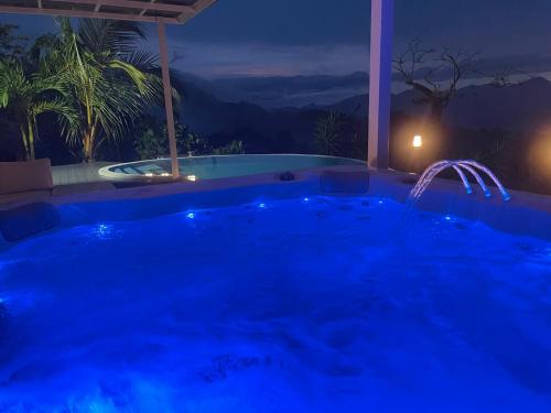 a swimming pool in a backyard at night at Palco Pacifico at The Retreat in Atenas